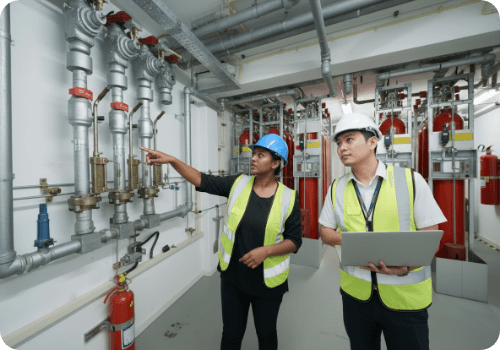 Technicians in safety vests inspecting fire suppression piping