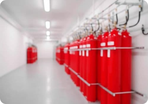 Row of fire suppression cylinders in a server room corridor